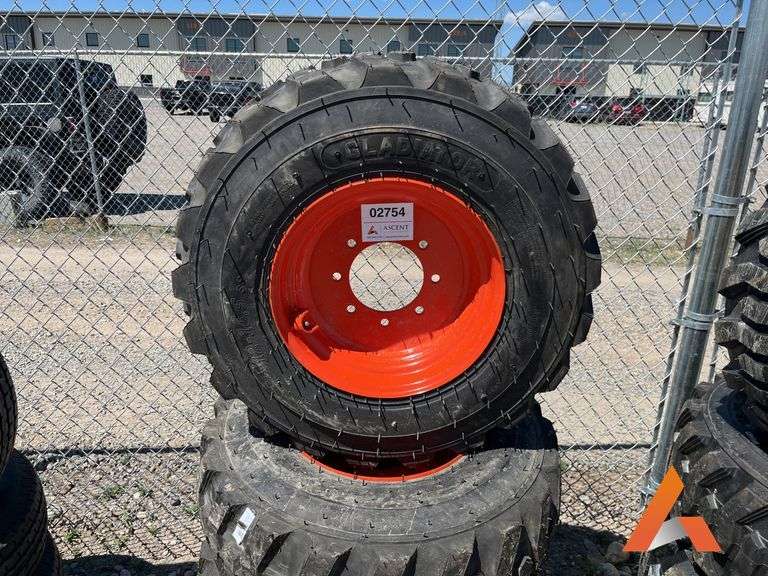 (4) Unused 12-16.5 skid steer tires on wheels for Bobcat
