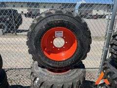 (4) Unused 12-16.5 skid steer tires on wheels for Bobcat