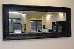 Ornate tin framed 33" x 72" beveled edge mirror