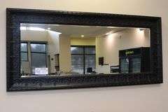 Ornate tin framed 33" x 72" beveled edge mirror