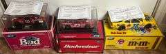 (3) 1:24 Scale Diecast Replica Cars w/ COA's, 1998 Budweiser/Louie Chevrolet Monte Carlo, 1998 Budweiser Chevrolet Monte Carlo, & 1998 M&M's Pontiac Grand Prix, All In Original Packaging