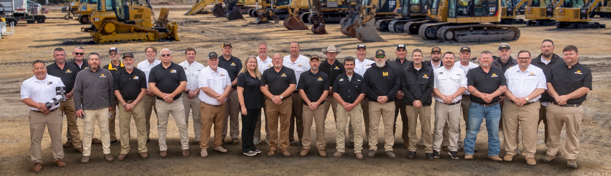 Jeff Martin Auctioneers team in front of the equipment line at an auction yard
