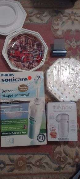 Box lot with Philips Sonicare toothbrush, True Glow heated lotion dispenser, Collector Plates